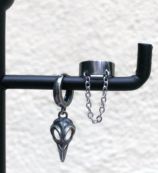 Zilveren heren ear cuff met ketting en raven skull hanger op display