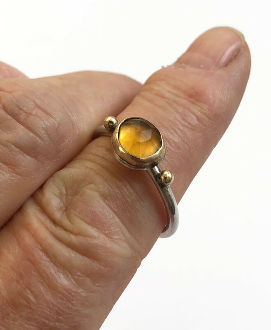 Handgemaakte zilveren en gouden stapelringen met een citrien edelsteen gedragen om de vinger