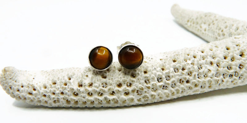 Detailopname van een 925 sterling zilveren heren oorsteker met een 6mm cabochon tijgeroog edelsteen