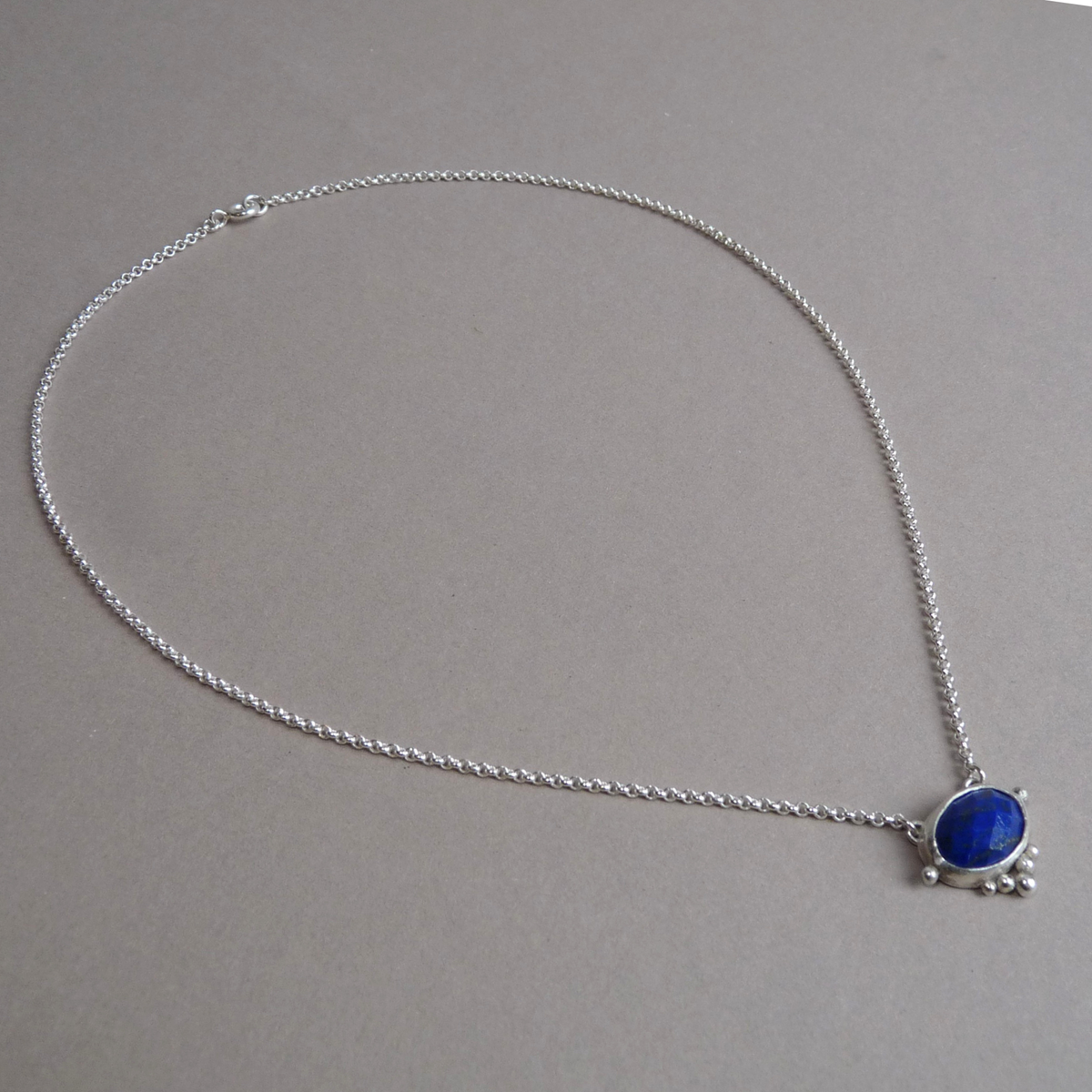 Overzicht van de sterling zilveren rolo ketting met de blauwe edelsteen hanger van lapis lazuli