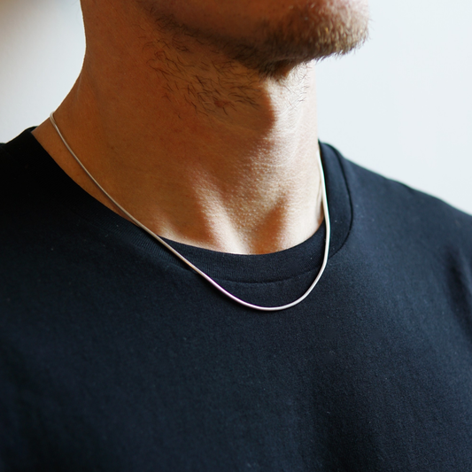 Minimalistische zilveren slangenketting van 1,6 mm dikte gedragen door een man